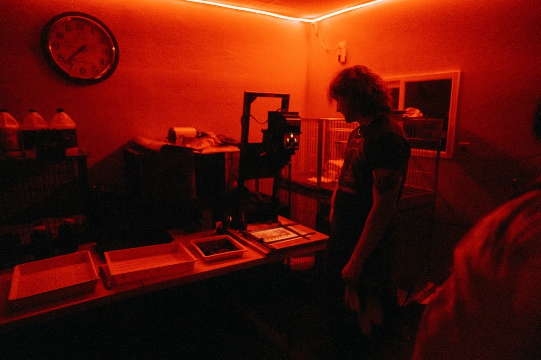 a woman standing in a dark room with a clock on the wall